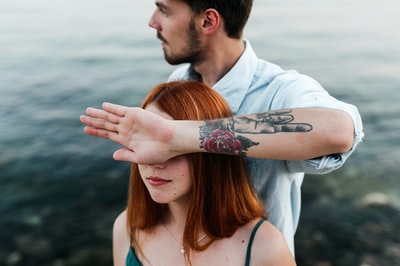 White shirt, the lady left cheek has a tattoo
